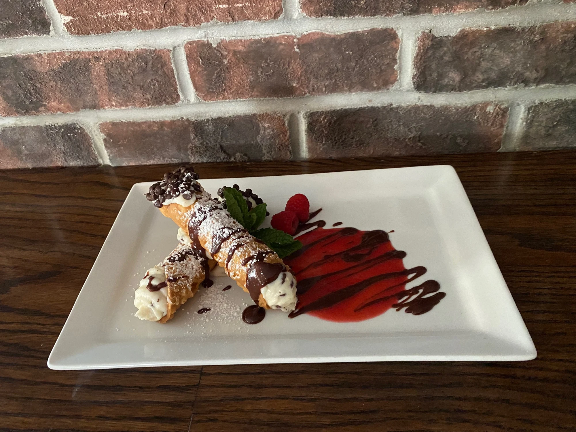 Cannoli with chocolate and raspberry drizzle